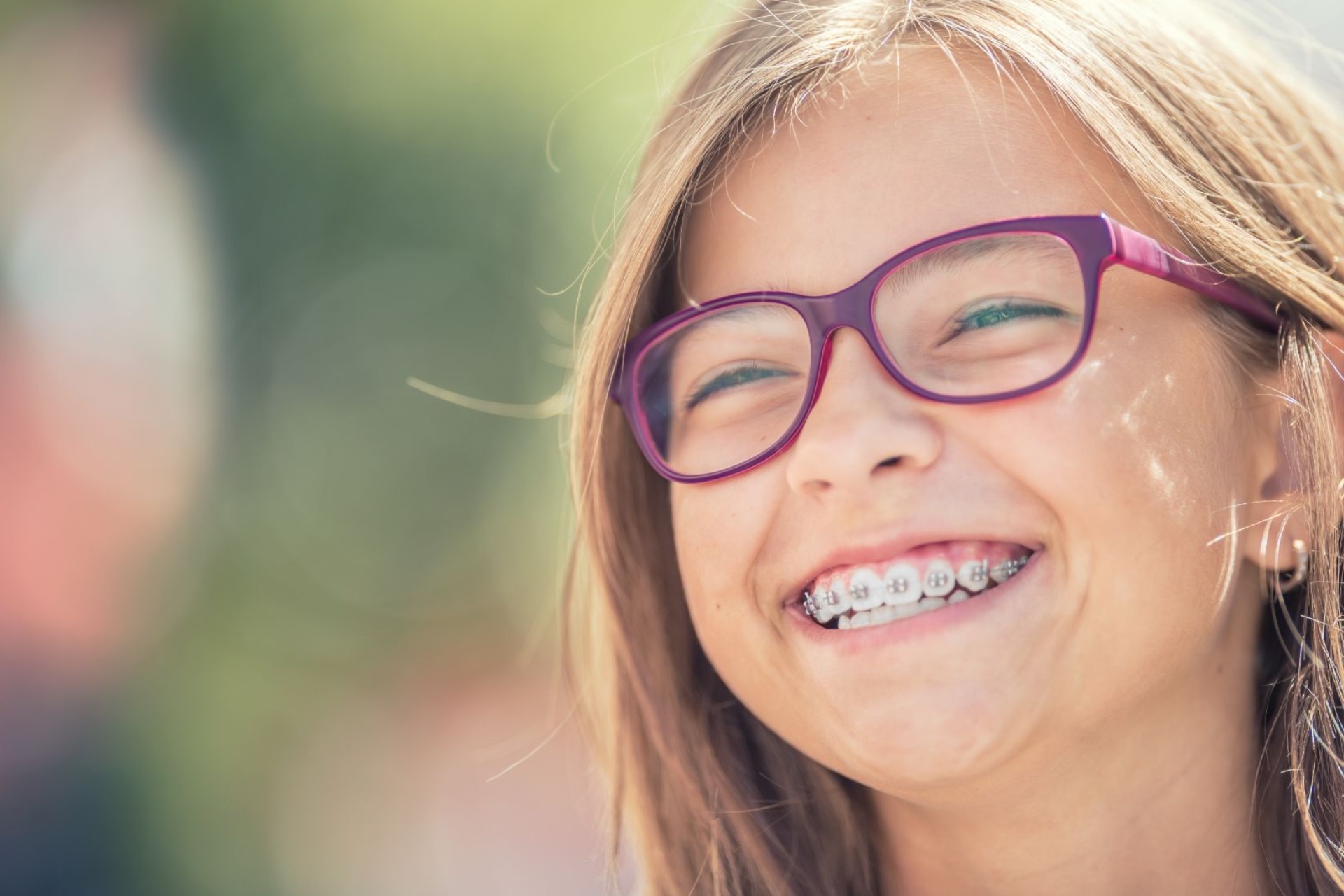 Niña con brackets y gafas sonríe