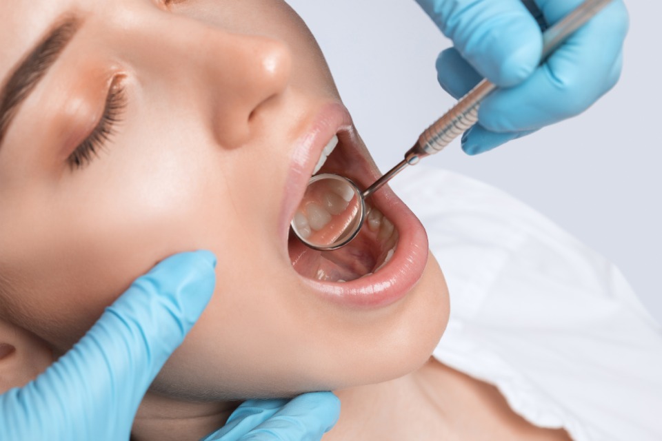Dentista revisa los dientes de una mujer
